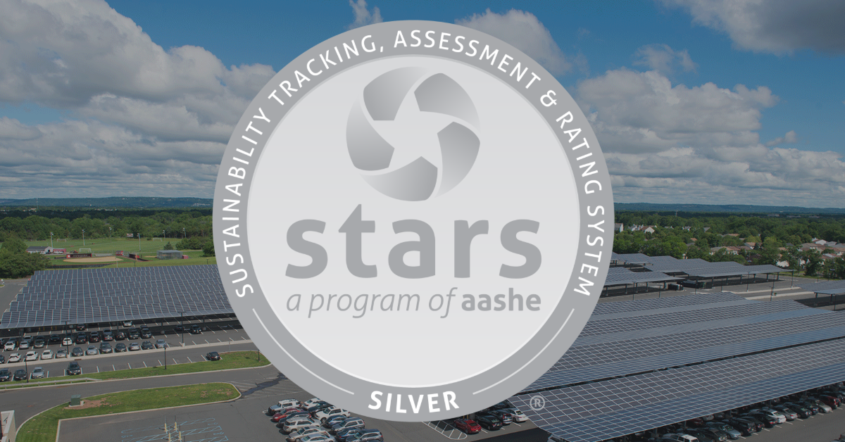 AASHE STARS silver seal in front of a solar panel aerial picture background