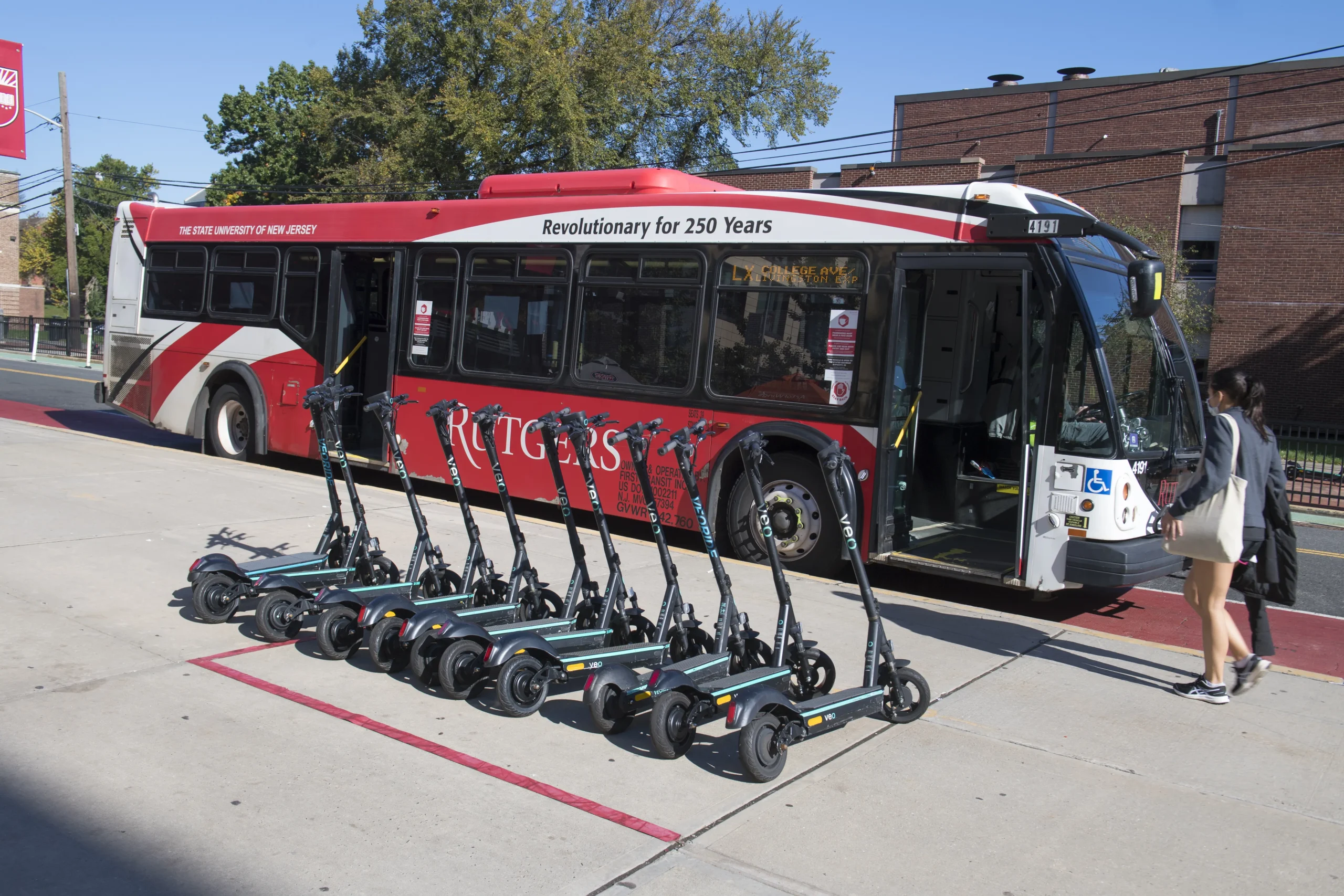 scooters in front of a rutgers bus